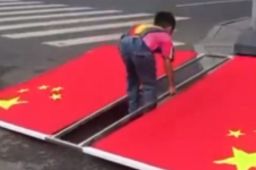 男孩将比自己大一圈的国旗扶正