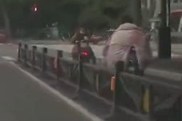 河南气温骤降 男子裹棉被骑车