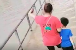 广东暴雨 妈妈带儿子边拍照边蹚水