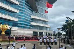 直升机挂国旗区旗飞过维多利亚港