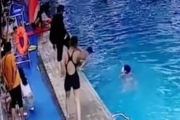 陌生男子将泳池边小孩踢下水