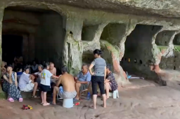 村民在墓穴躺坐一排乘凉：人多不怕