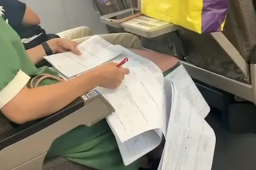 老师在返程高铁上卖力改试卷